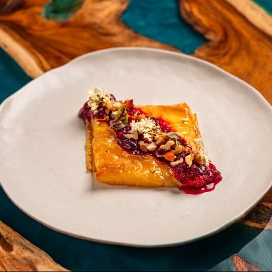 Baked halloumi with cranberry — Golden baked halloumi wrapped in delicate filo dough and glazed with honey. Served with cranberry co