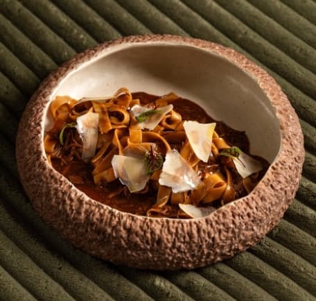 Beef pappardelle — Wide pappardelle pasta served with slow-cooked 4-hour beef stew, parmesan, parsley, and garlic oil.