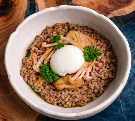 Buckwheat with egg and parmesan — Nutty buckwheat served with parmesan, mushrooms, garlic oil, and a soft egg. Rich flavors and creamy