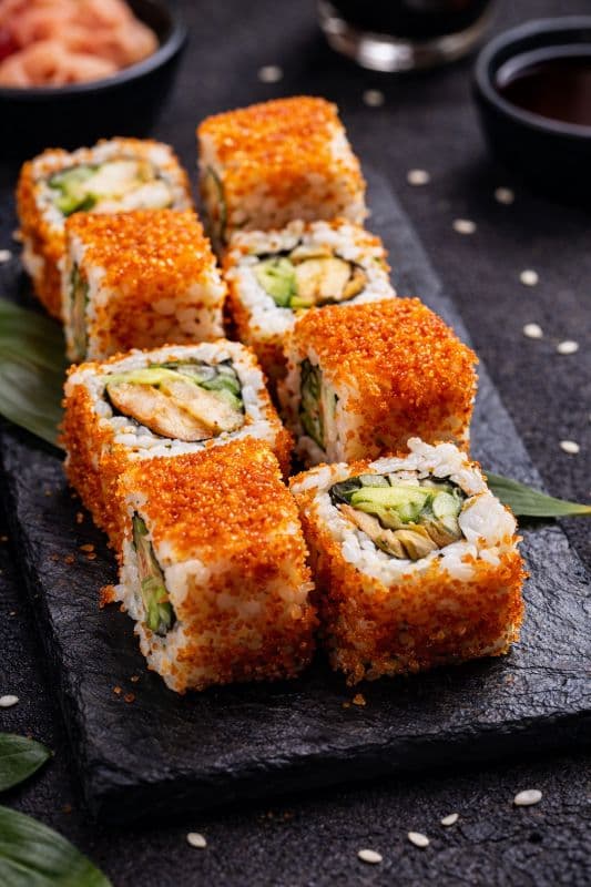 California Uramaki 8 pcs — A popular roll with shrimps, avocado, cucumber and covered in red tobiko- a harmony of flavor and te