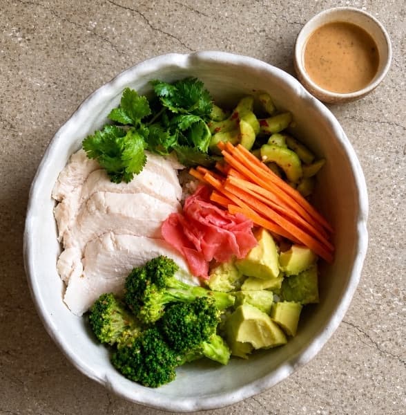 Chicken poke — A fresh poke bowl with Japanese rice, sous-vide chicken breast, avocado, broccoli, cucumber, carrot,