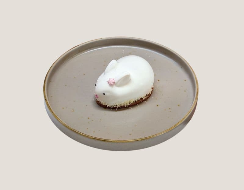 BUNNY COCONUT — Fluffy coconut mousse.
Inside — white chocolate, almonds, and creamy condensed milk.
A crunchy lay