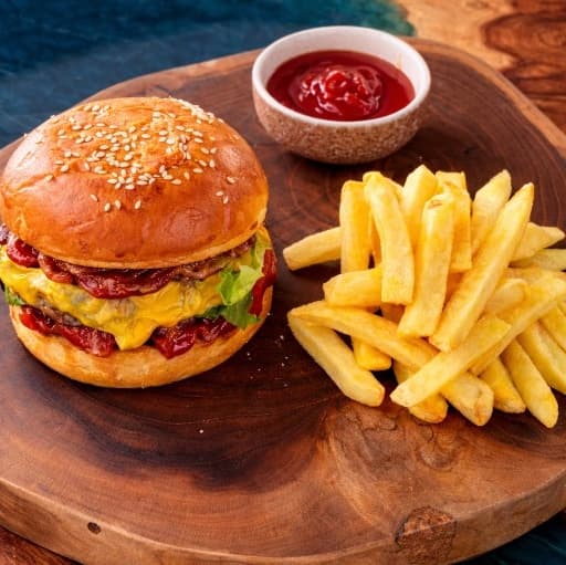 Marble Beef Burger — A juicy Black Angus beef burger with melted cheddar, BBQ sauce, pickles, and fresh romano salad on a
