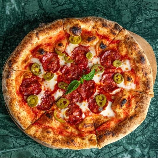 Pepperoni jalapeno — Spicy Neapolitan-style pizza with mozzarella, pepperoni, and marinated jalapenos on rich tomato sauc