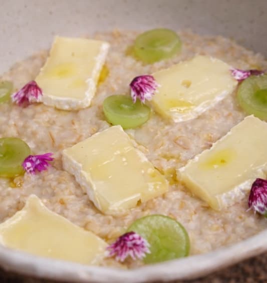 Savoury oatmeal with brie — Creamy oatmeal with parmesan and butter, topped with delicate brie and sweet fresh grapes. A cozy go