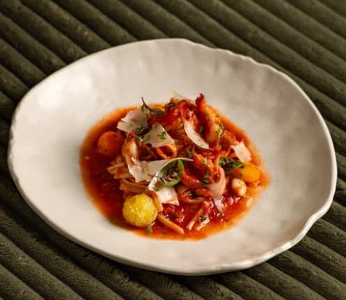 Seafood spaghetti — Spaghetti in rich tomato sauce with shrimp, squid, baked cherry tomatoes, and parmesan. Fresh seafoo